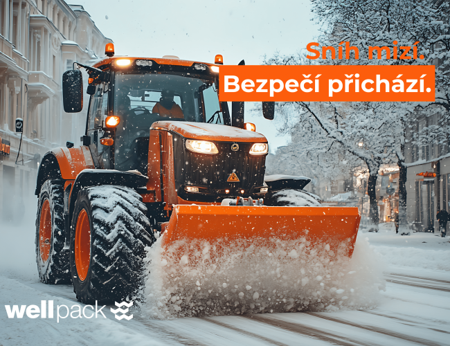 Traktor s oranžovou radlicí odhrnuje sníh v centru města – zimní údržba Wellpack