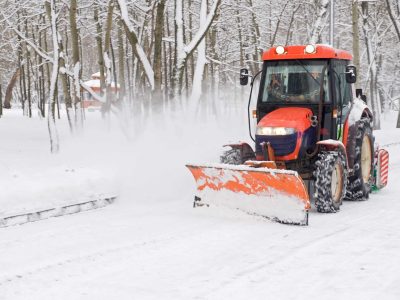 Winter snow removal a small tractor in the park