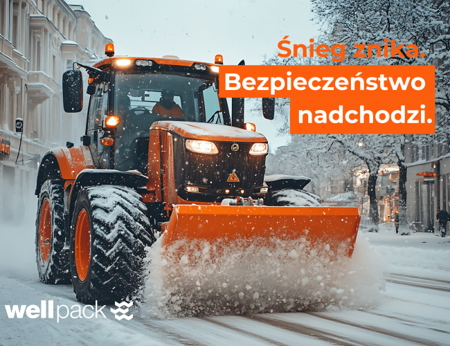 Traktor z pomarańczowym pługiem odśnieża ulice w centrum miasta – zimowe utrzymanie Wellpack